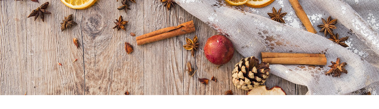 Aufnahme eines Holztisches, der mit einer Tischdecke, Zimtstange und getrockneten Obst dekoriert ist.