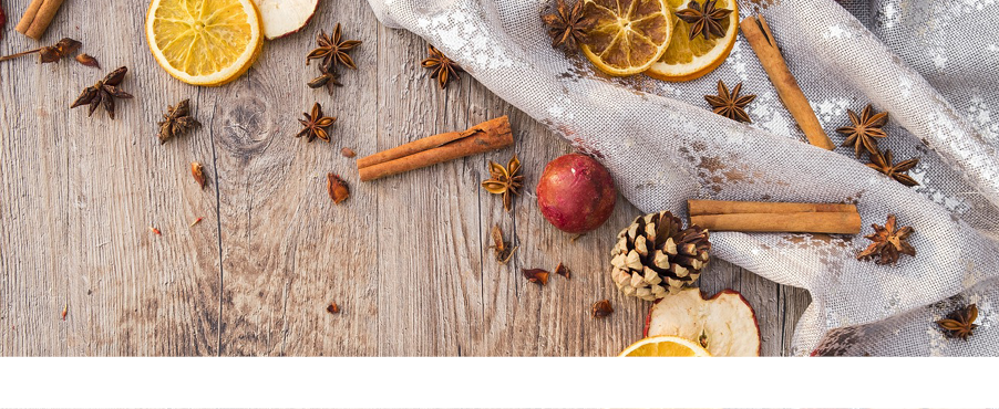 Aufnahme eines Holztisches, der mit einer Tischdecke, Zimtstange und getrockneten Obst dekoriert ist.