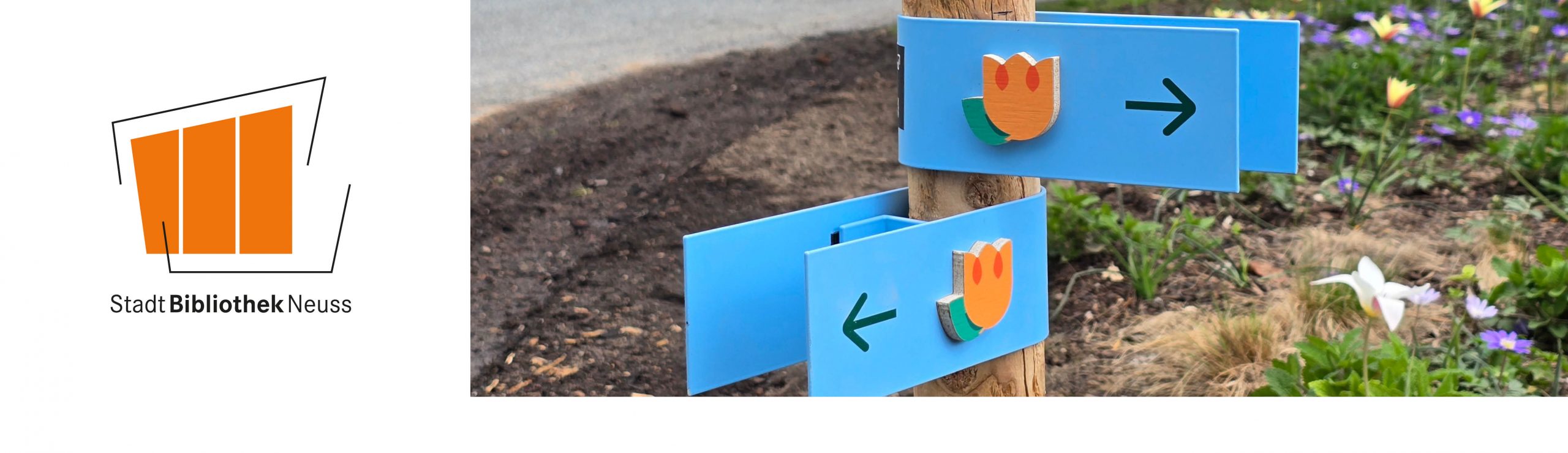 Auf dem Foto ist ein Wegweiser mit Richtungsschildern abgebildet, der auf die Landesgartenschau 2026 in Neuss zeigt. Daneben ist das Logo der Stadtbibliothek Neuss zu sehen.