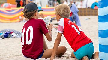 Kinder sitzen im Sand und Lesen
